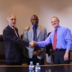 Fred Higgs (à droite) quittant le poste de Secrétaire général de l'ICEM dont il confie les rênes à Manfred Warda (à droite) en 2006, sous le regard du Président de l'ICEM, Senzeni Zokwana. 